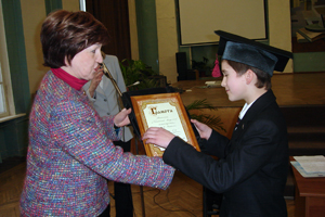 Директор гимназии Л. М. Мардер вручает награду Михаилу Кузнецову